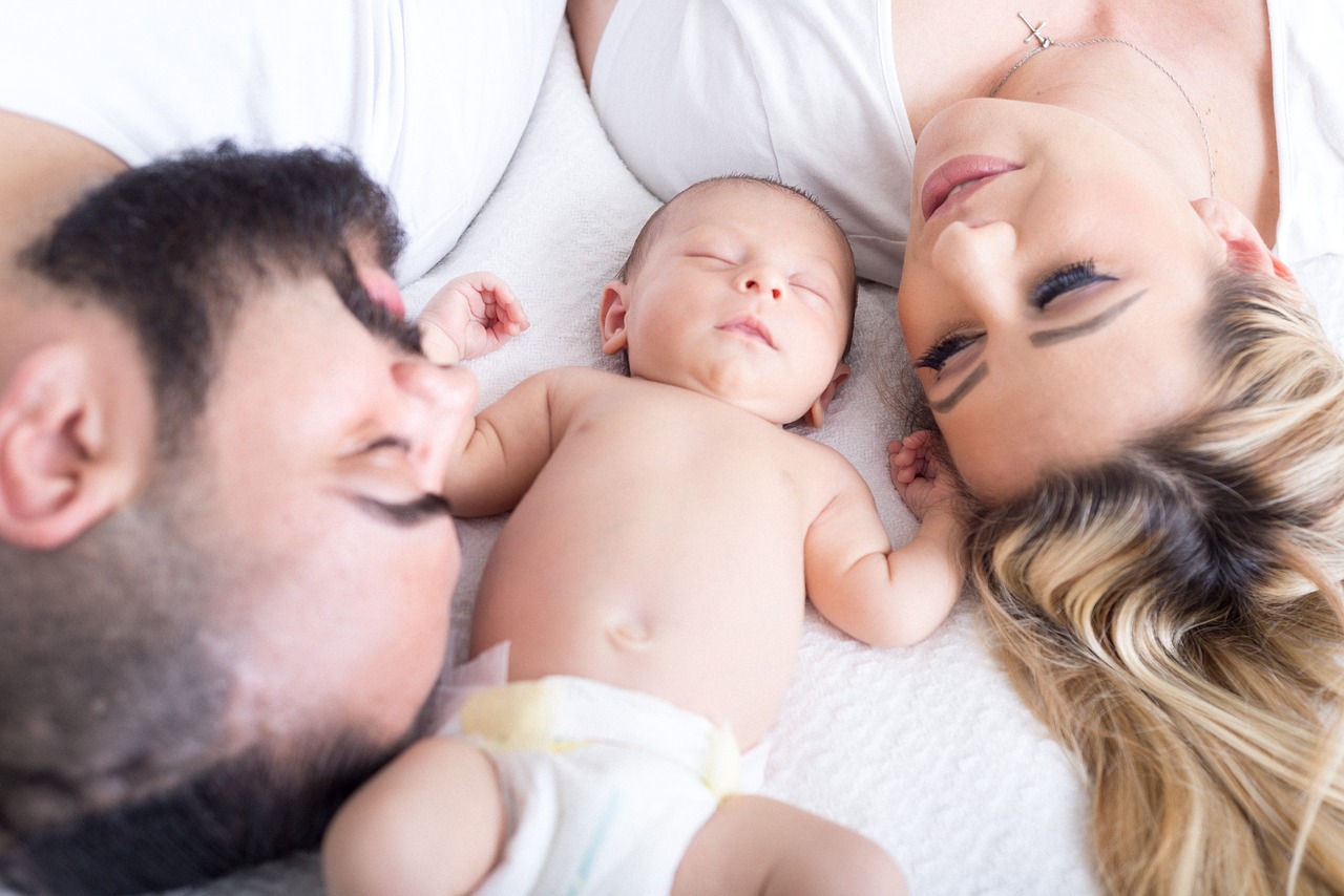 new parents lay beside their infant